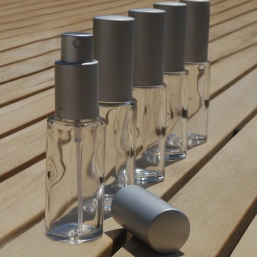 Lasipullo hopeanvärisellä sumuttimella ja korkilla